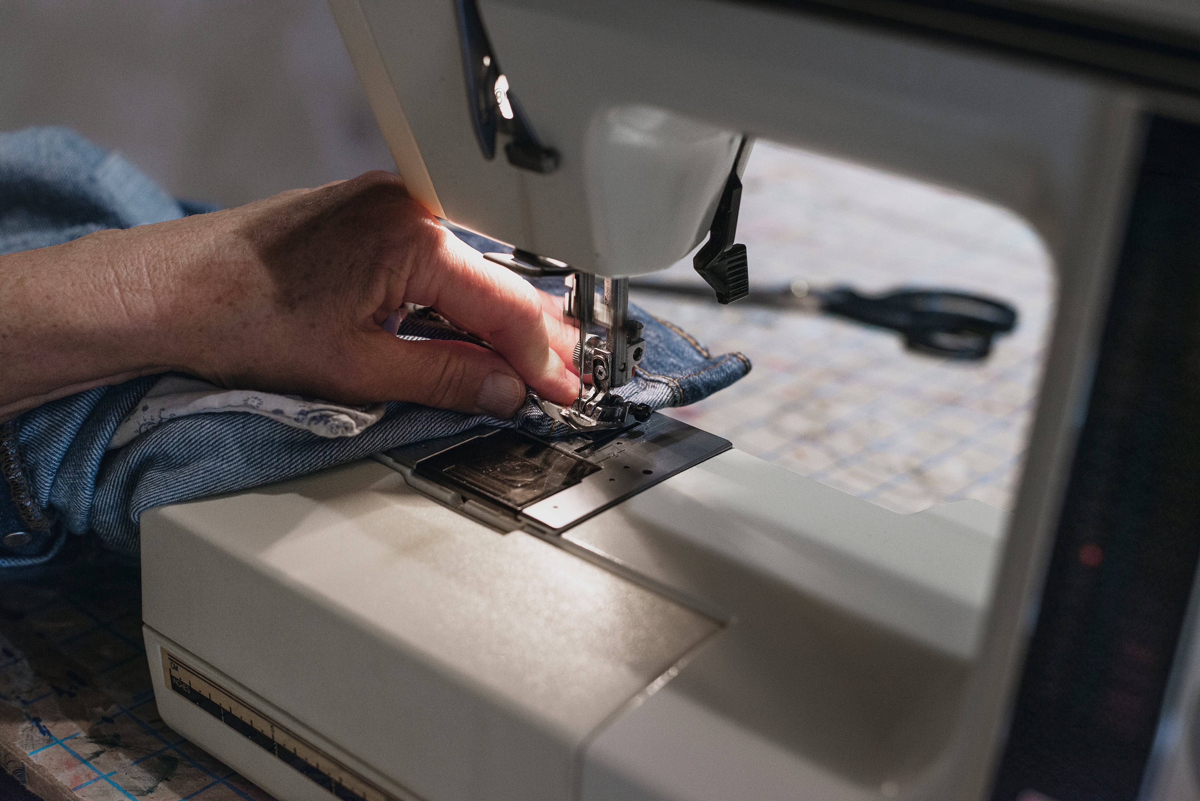 hand-uses-sewing-machine-on-denim.jpg